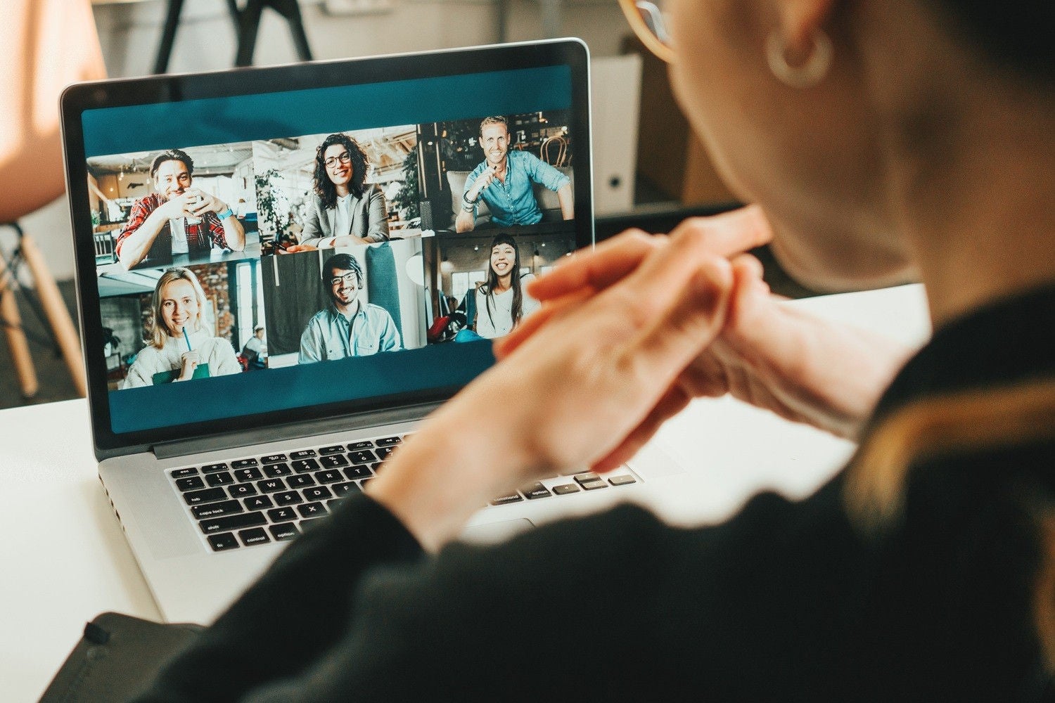 Woman has video conference with her remote team using laptop and camera