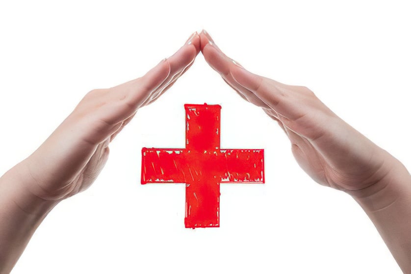 White female hands acting as a roof and protecting the red cross sign. Health insurance concept isolated on white background.