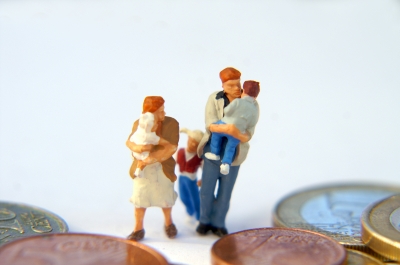 Familie aus Spielzeugfiguren steht auf Euromünzen